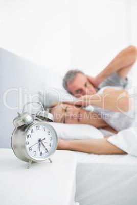 Couple blocking their ears from alarm clock noise