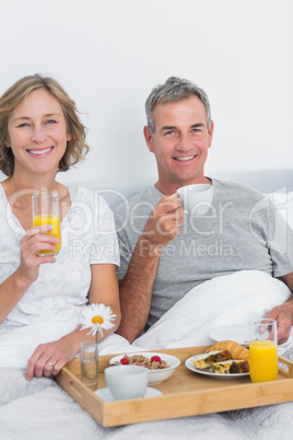 Content couple having breakfast in bed together