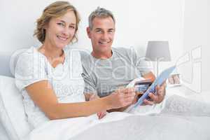 Happy couple using their tablet pc to buy online