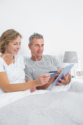 Relaxed couple using their tablet pc to buy online