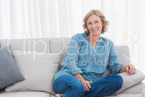 Blonde woman sitting on her couch