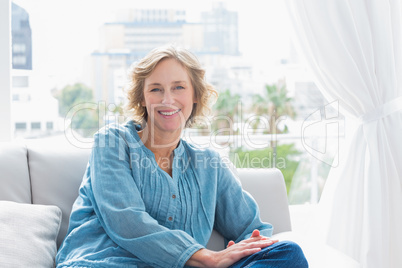 Content blonde woman sitting on her couch