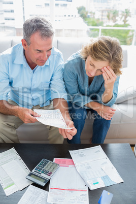 Couple sitting on their couch paying their bills