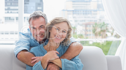 Content man hugging his wife on the couch