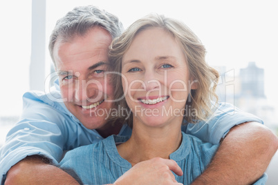 Happy man hugging his wife from behind