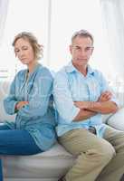 Middle aged couple sitting on the sofa not speaking after a disp