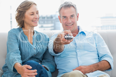 Happy couple sitting on the couch watching tv