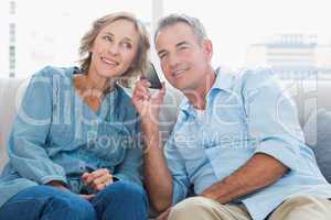 Cheerful couple listening to mobile phone together