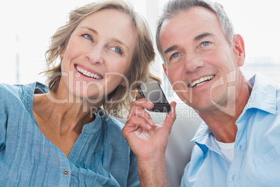 Happy couple listening to mobile phone together