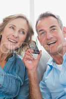 Smiling couple listening to mobile phone together