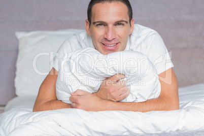 Happy man hugging his pillow