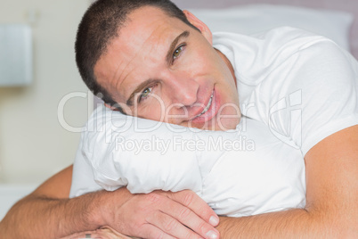 Attractive man hugging his pillow