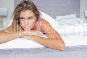 Thoughtful blonde lying on her bed