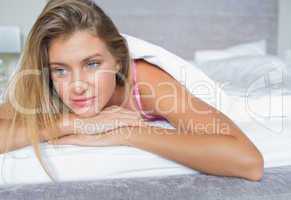 Beautiful blonde lying in her bed thinking