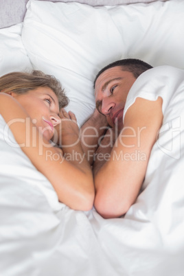 Cute couple lying together in bed