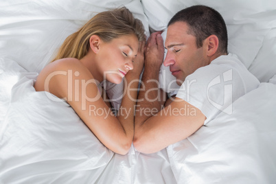 Cute couple lying asleep in bed