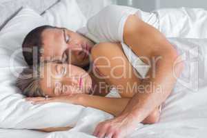 Cute couple sleeping and cuddling in bed