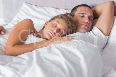 Attractive couple sleeping and cuddling in bed