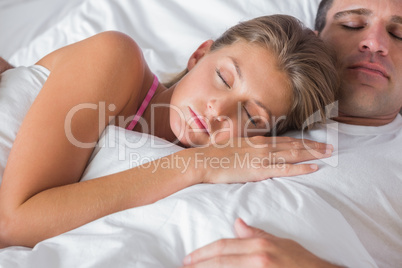 Peaceful couple sleeping and cuddling in bed