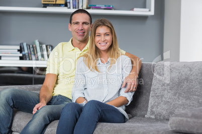 Happy young couple sitting on their couch