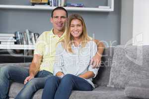 Happy young couple sitting on their couch