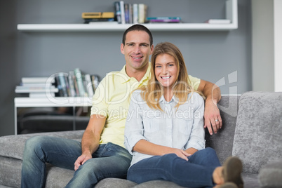 Attractive young couple sitting on their couch