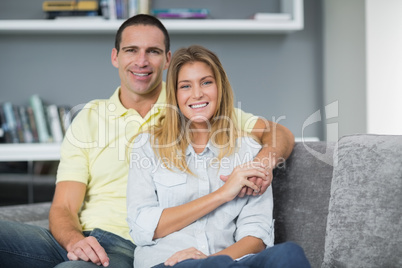 Smiling young couple sitting on their couch