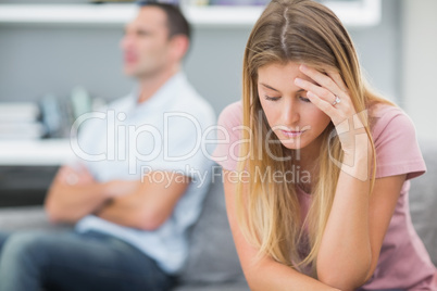 Upset woman thinking on couch after fight with husband