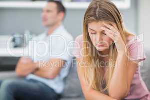 Upset woman thinking on couch after fight with husband