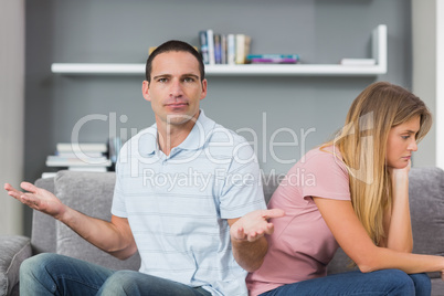 Couple sitting back to back after a fight on the couch with man