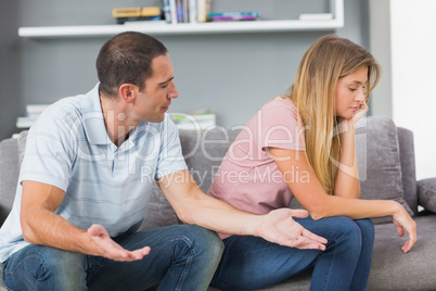 Couple sitting on the couch having an argument