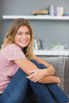 Smiling blonde sitting on her sofa Smiling blonde sitting on her sofa