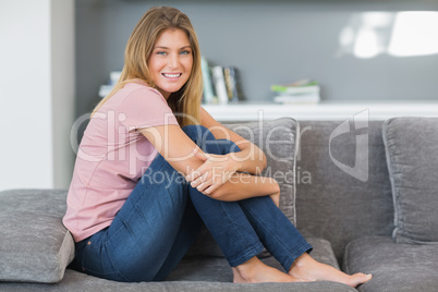 Attractive blonde sitting on her sofa