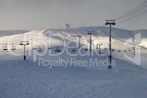 ski slope with chair-lift in evening