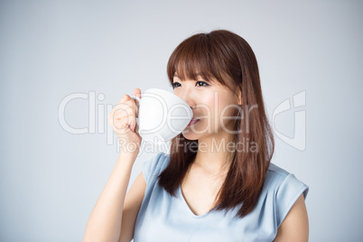 Asian woman drinking a cup of coffee