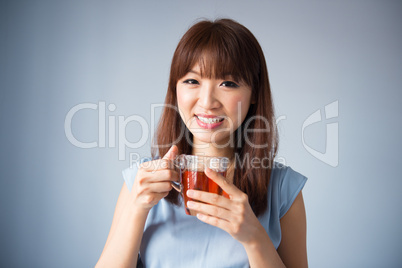 Asian woman drinking a cup of tea