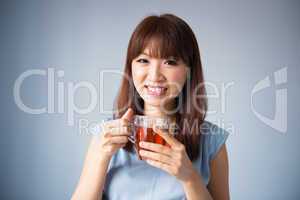 Asian woman drinking a cup of tea