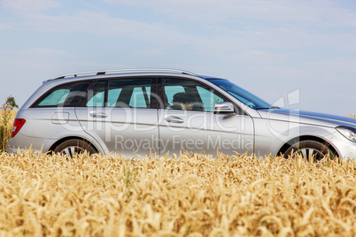 Woman driving car in front of the cereal field