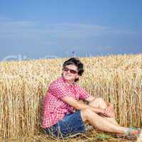 Woman sitting in front of the wheat field