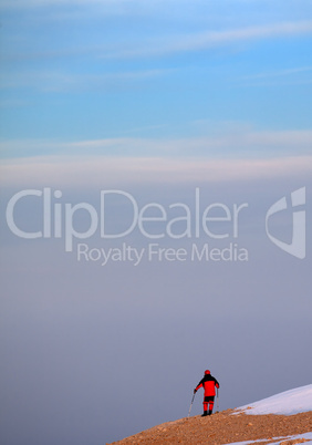 hiker on edge of cliff in sunrise