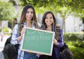 Mixed Race Female Students Holding Blank Chalkboard