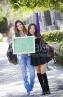 Excited Mixed Race Female Students Holding Blank Chalkboard