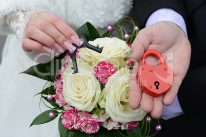 couple's hands holding wedding lock