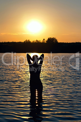 girl standing in the lake at sunset