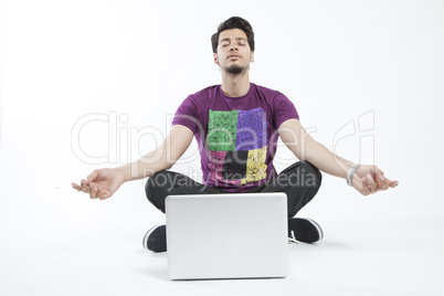 Man meditating infront of a laptop