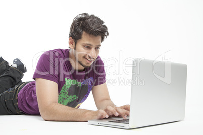 Young male relaxed working on laptop