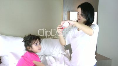 Little girl in bed taking medicine