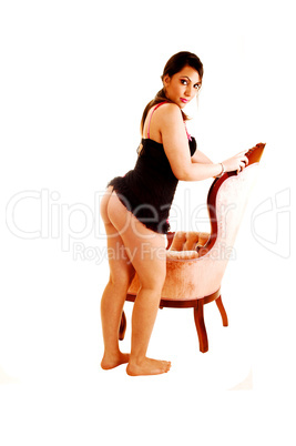 Girl standing on armchair.