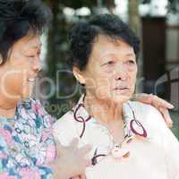 Mature woman consoling her crying old mother