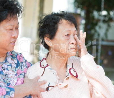 Sadness senior woman wiping off her tears